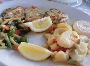 Una foto de Gallineta al horno con verduras y vino