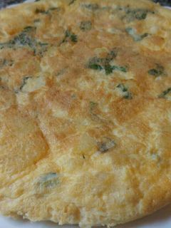 Una foto de Tortilla de patatas, ajos y hierbabuena