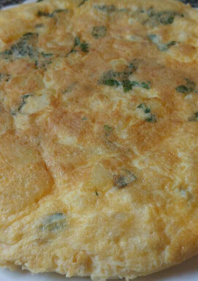 Una foto de Tortilla de patatas, ajos y hierbabuena