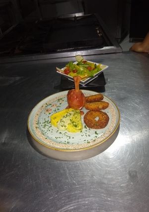 Una foto de Pollo albardado con jamón serrano, mix de purés, aros de cebolla