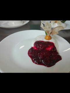 Una foto de Panna cotta de vainilla con coulis de frutos rojos
