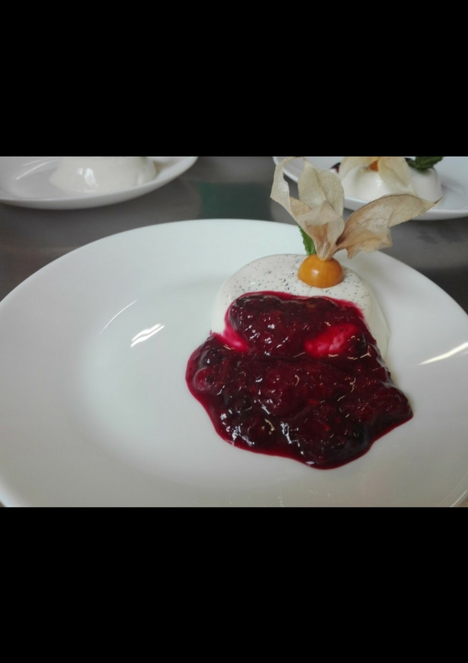 Una foto de Panna cotta de vainilla con coulis de frutos rojos