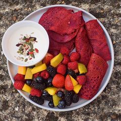 A picture of Beetroot pancakes with berries, mango with vegan yoghurt+seeds.