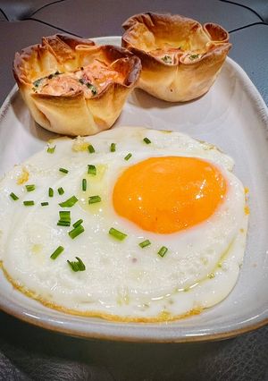 Una foto de Desayuno: tartaletas de bacon y queso con huevo frito