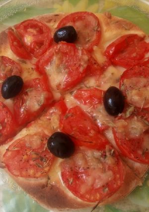 Une photo de Pizza aux tomates 🍕 🍅