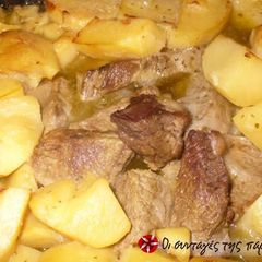 A picture of Beef with potatoes in the oven.