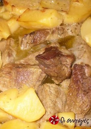 A picture of Beef with potatoes in the oven.