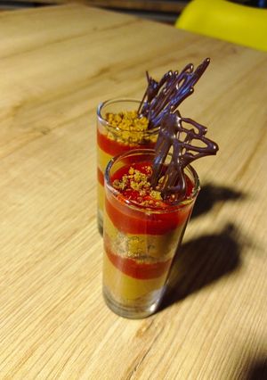 Una foto de Mousse de Chocolate amargo y chile ancho con coulis de fresa