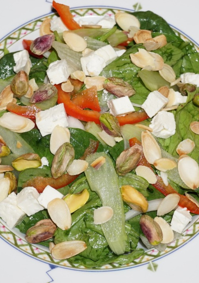 Una foto de ENSALADA DE ESPINACA BABY, ICEBERG CON QUESO DE CABRA, PISTACHO Y ALMENDRAS
