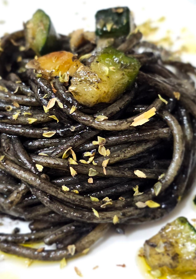 Una foto de Espaguetis con tinta, y gambas con calabacín