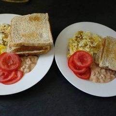 A picture of Breakfast of eggs, tomato and baked beans.