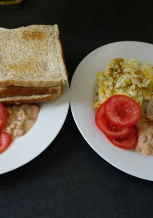 A picture of Breakfast of eggs, tomato and baked beans.