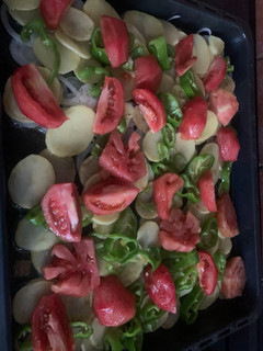 Una foto de Patatas al horno con tomate, pimiento y cebolla