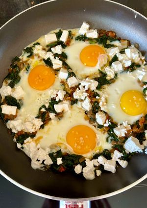 A picture of Saganaki 🍳 with Eggs 🥚, Feta, Spinach 🌿, and Tomato 🍅 in a Skillet 🥘.