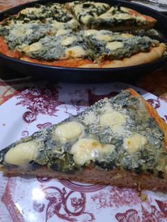 Una foto de Pizza con espinaca, queso azul y parmesano