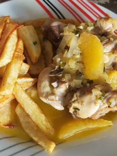 Una foto de Conejo a la naranja con patatas fritas