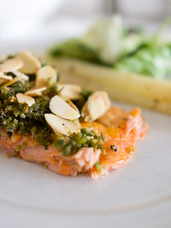 Una foto de Salmón con pesto crujiente y almendras anaranjadas