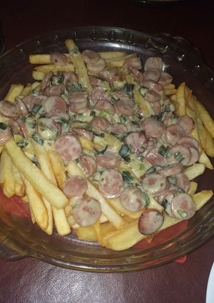 Una foto de Fritas con salsa de crema de verdeo y salchichas