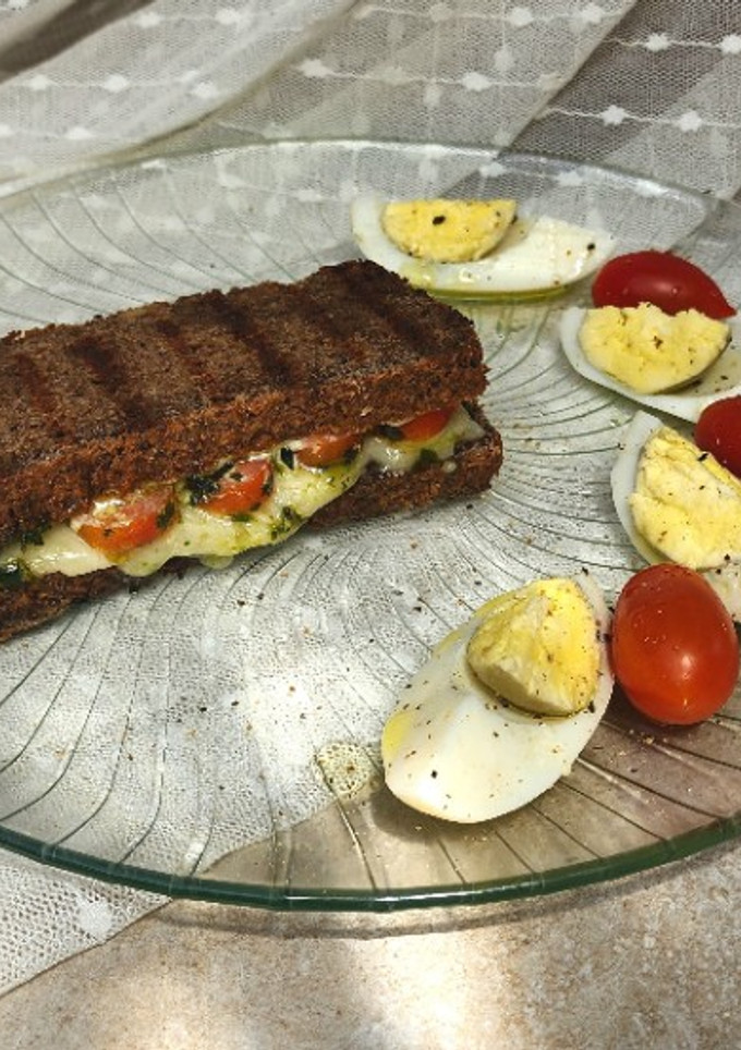 Una foto de 🌿🍅🧀 Sándwich caprese con pan de lentejas 🧀🍅🌿 Tomates cherry, muzzarella y pesto de albahaca