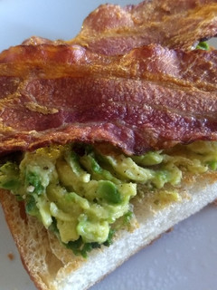 Una foto de Pan tostado con aguacate y tocino crujiente