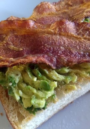 Una foto de Pan tostado con aguacate y tocino crujiente