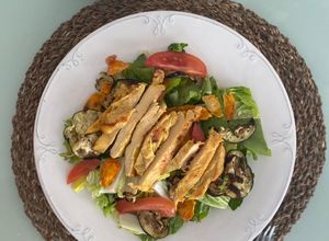 Una foto de Ensalada verde con pollo y vegetales cocidos en microondas