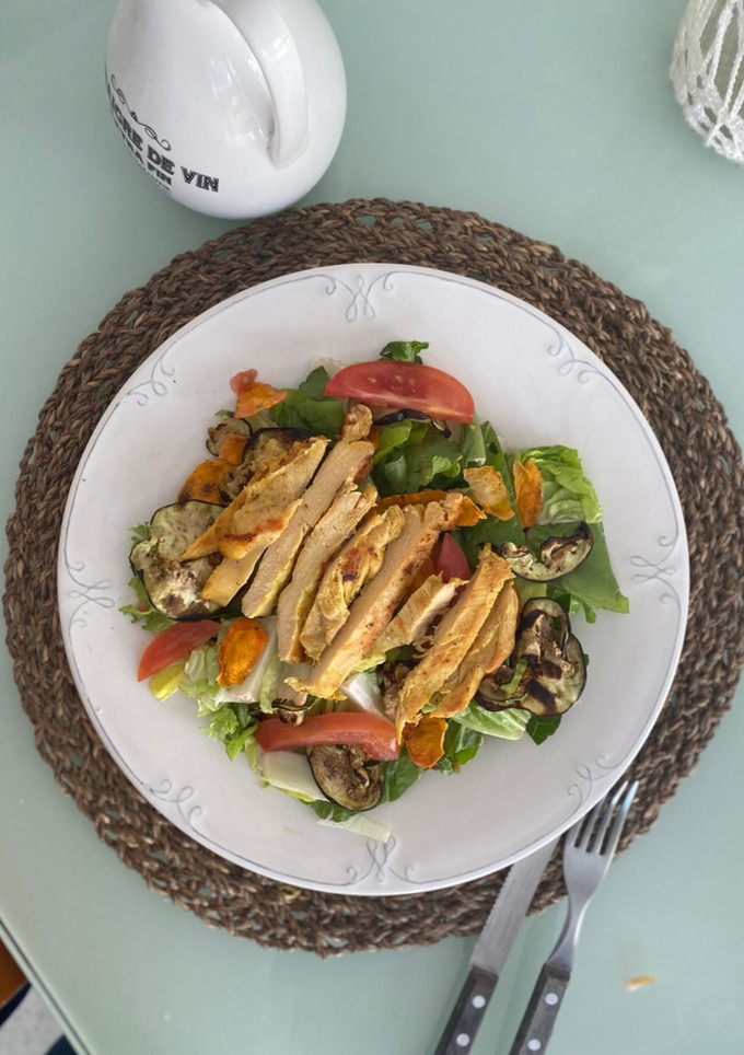 Una foto de Ensalada verde con pollo y vegetales cocidos en microondas