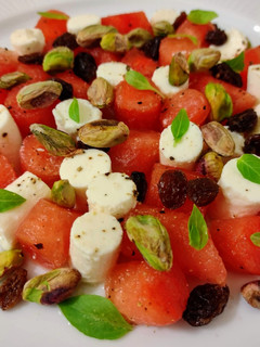 Una foto de Ensalada de sandía, feta, frutos secos y albahaca