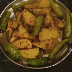 A picture of Fried potato with fried green chilli.
