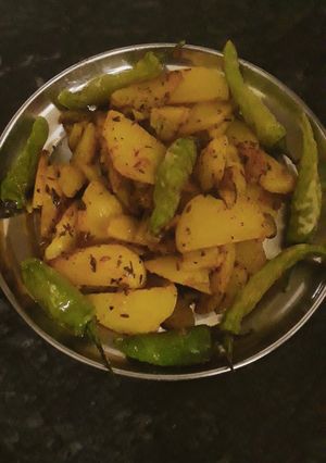 A picture of Fried potato with fried green chilli.