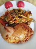 Contramuslos de pollo a la provenzal sobre una cama de verduras especiadas al horno