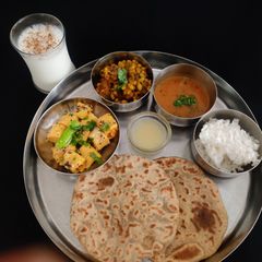 A picture of Gujarati Thali For lunch or dinner (puran poli khandvi,dana muthiya sabji,rice,dal).