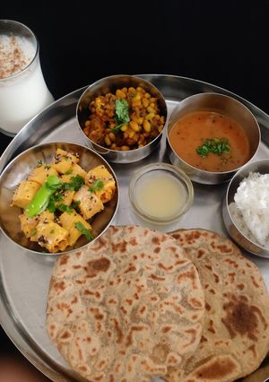 A picture of Gujarati Thali For lunch or dinner (puran poli khandvi,dana muthiya sabji,rice,dal).