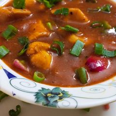 A picture of Restaurant style chicken shashlik with gravy.