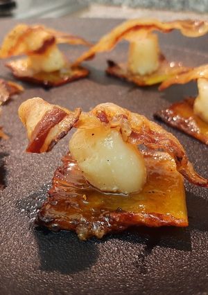 Una foto de Piña caramelizada, ostión salteado y panceta crocante