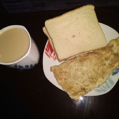 A picture of Ginger tea, omelette and bread.