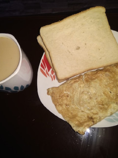 A picture of Ginger tea, omelette and bread.