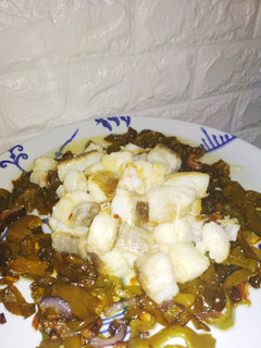 Una foto de Tacos de bacalao sobre cama de pimientos y cebolla