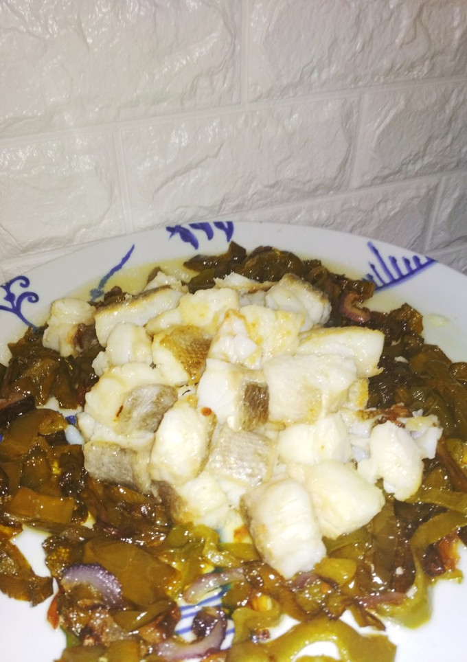 Una foto de Tacos de bacalao sobre cama de pimientos y cebolla