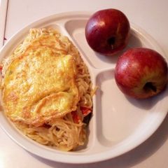 A picture of Fried Noodles, Freid egg and Red Apple.