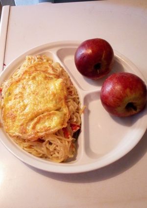 A picture of Fried Noodles, Freid egg and Red Apple.