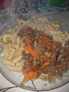 Una foto de Wok de carne y verduras, acompañado con fideos tirabuzón