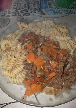 Una foto de Wok de carne y verduras, acompañado con fideos tirabuzón