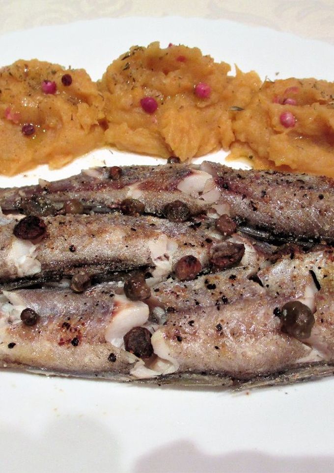 Una foto de Merlucitas al horno con puré naranja