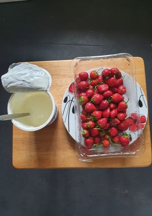 A picture of Strawberries and sweetened Yoghurt.