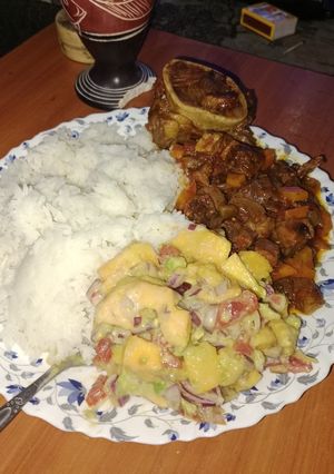 A picture of Rice,beef stew and mango salad.