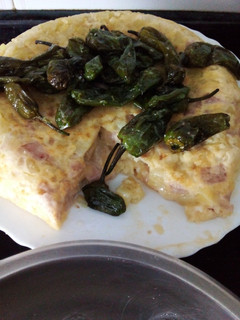 Una foto de Tortilla de patatas con york y queso y pimientos de Padrón fritos