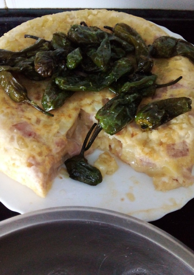 Una foto de Tortilla de patatas con york y queso y pimientos de Padrón fritos
