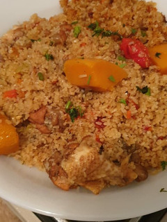 Una foto de Arroz dorado con pollo y verduras estilo senegalés