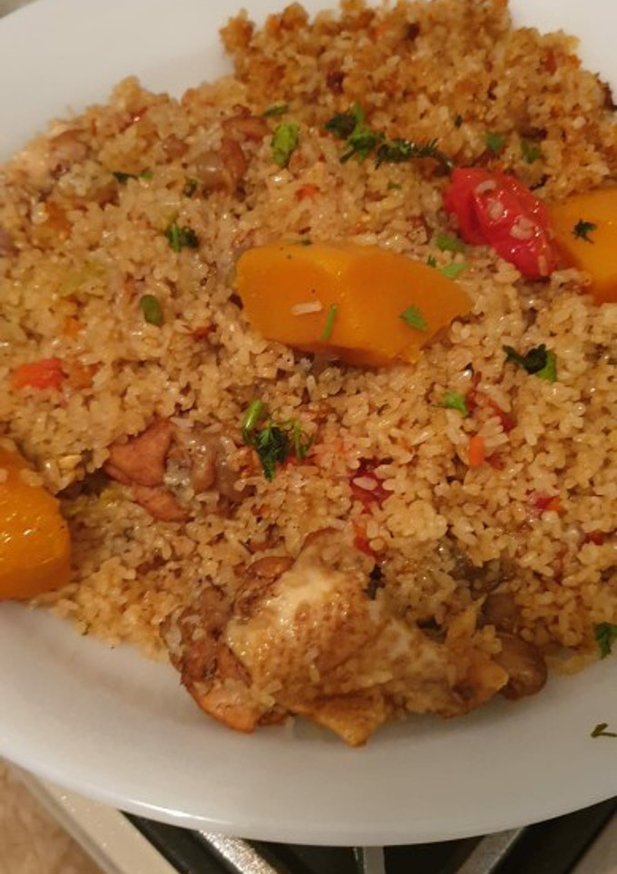 Una foto de Arroz dorado con pollo y verduras estilo senegalés